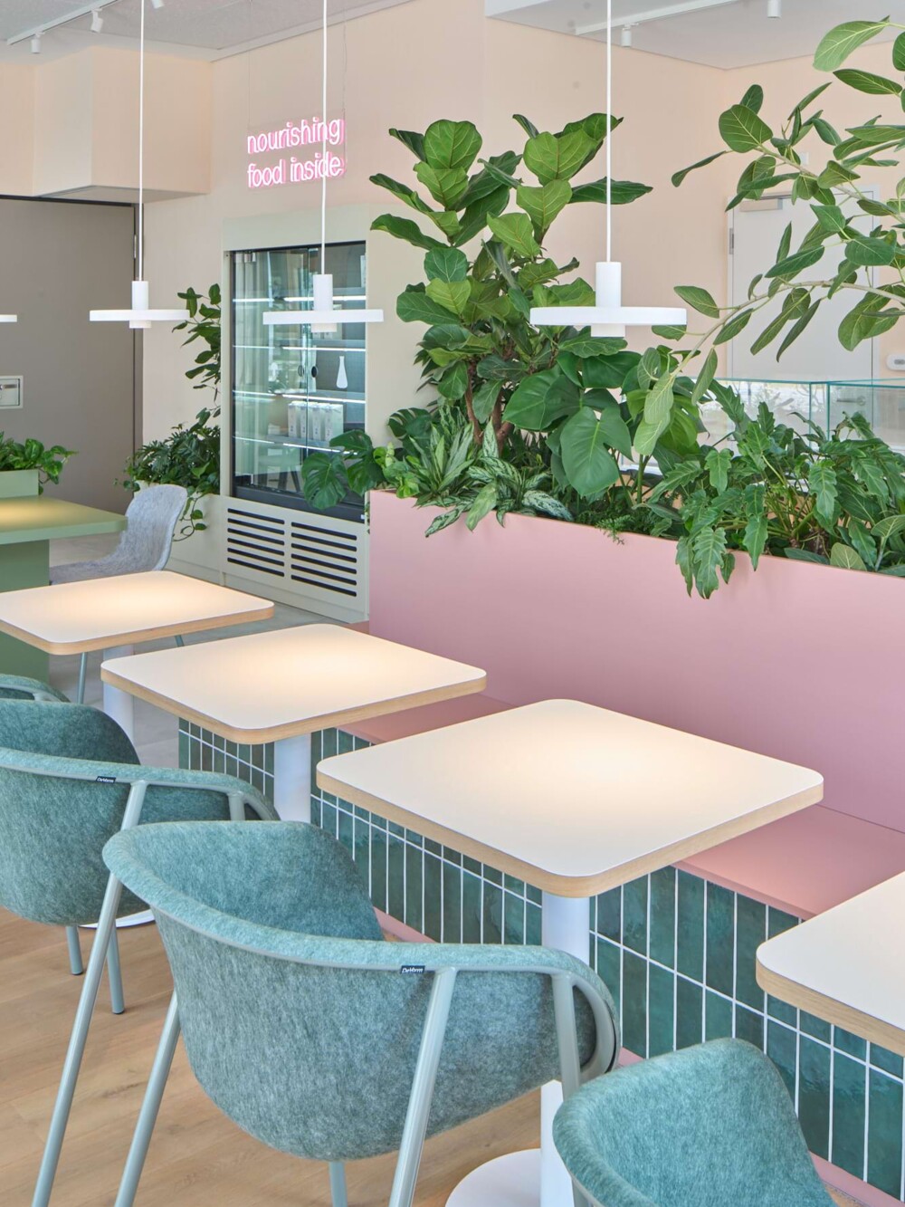 Effiziente Raumplanung im Apoteka Café: Modulares Tischsystem neben den fest installierten Pflanzkästen. Das Design integriert Natur, schafft Ordnung und maximiert die Sitzkapazität im Science Park Tübingen