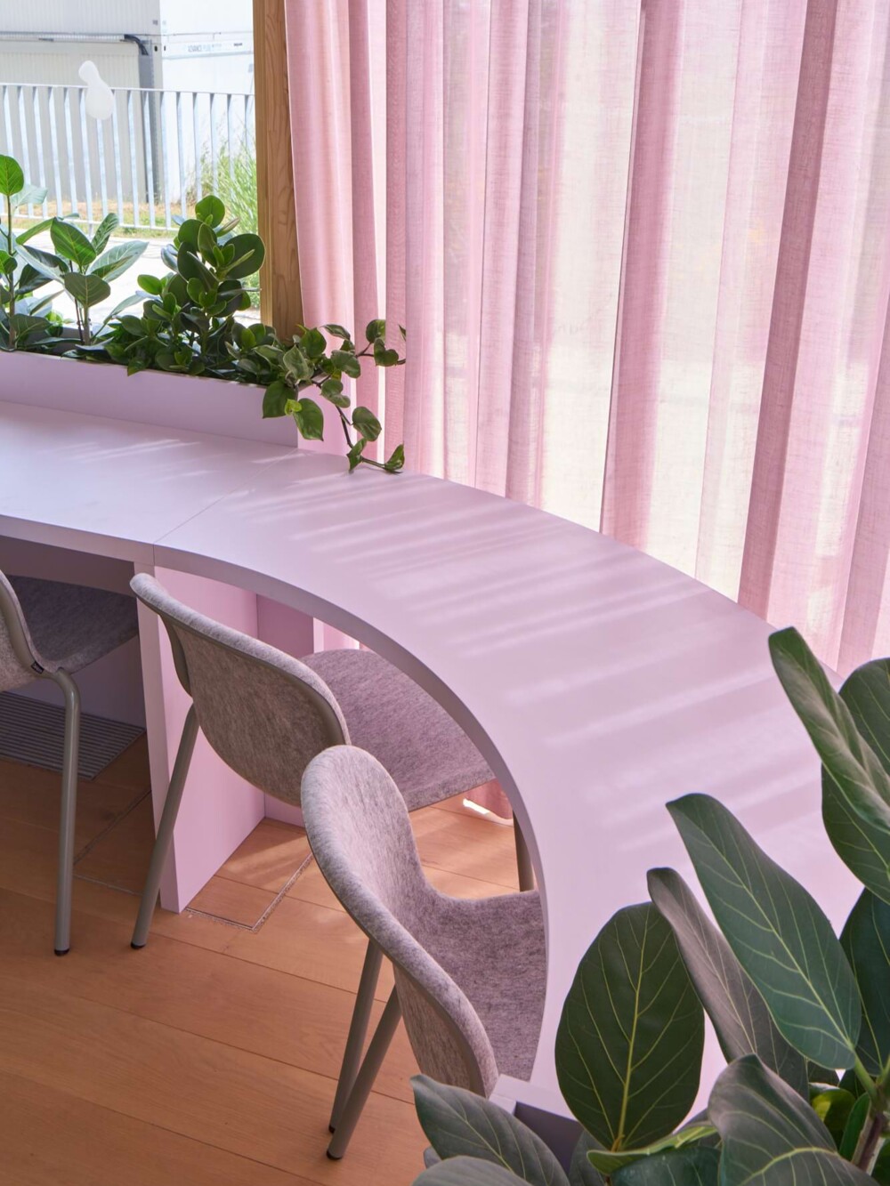 Sonderanfertigung Sitzmöbel: Geschwungener, maßgefertigter Hochtisch aus hellem Material. Das Stuttgarter Werkkollektiv setzte diese organische Konstruktion um, ergänzt durch lichtdurchlässige Vorhänge